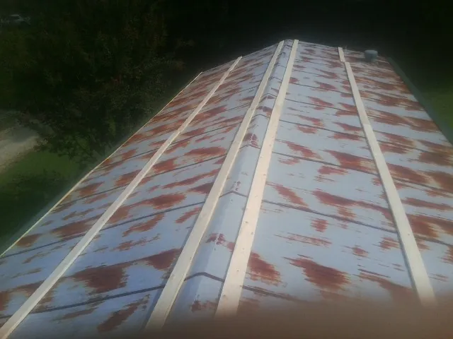 Rusted metal roof panels with new wood purlins before replacement — Storm Damage Roof Repair in East Palestine by Roofing Brothers