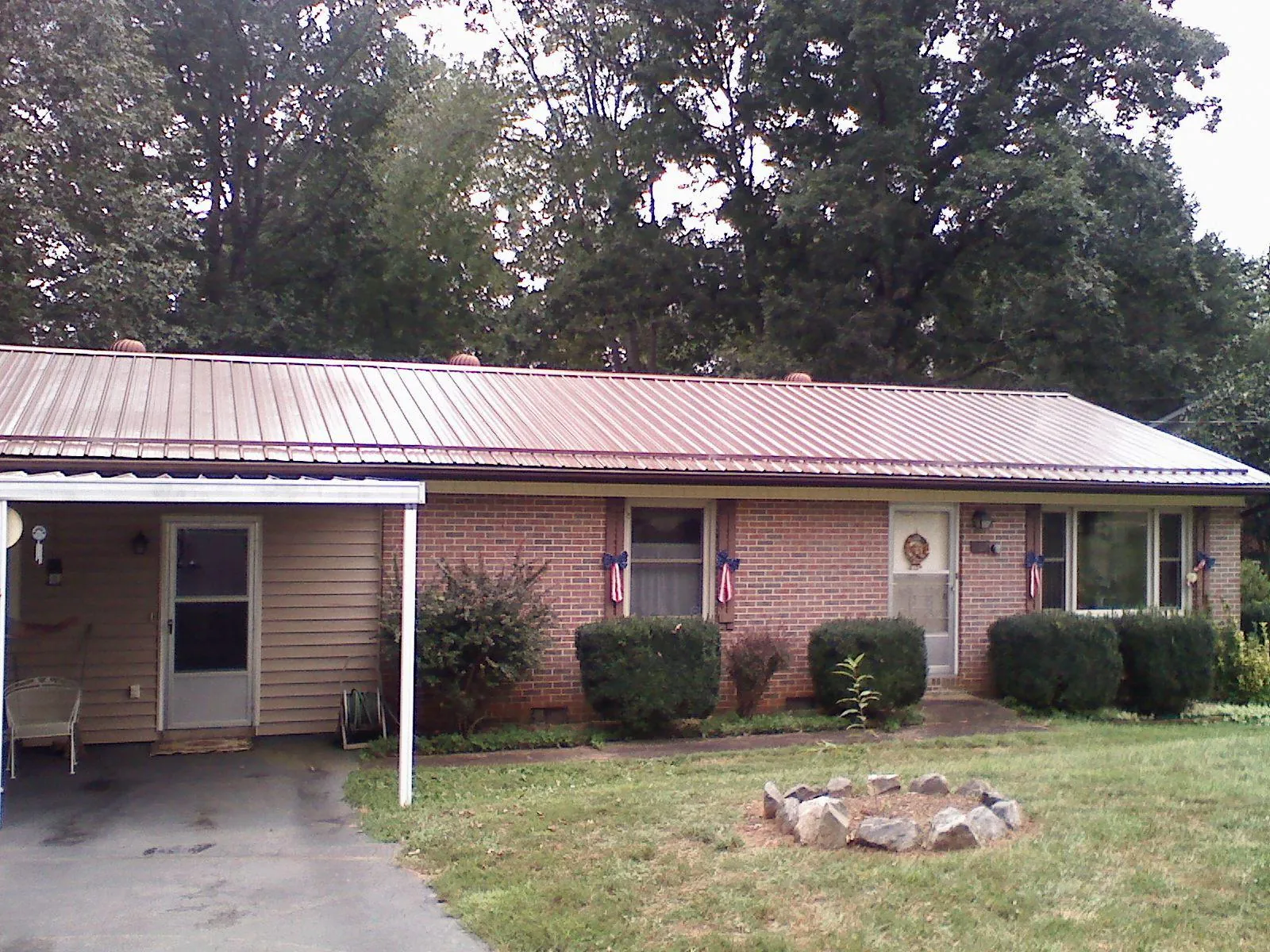 Bronze metal roof and carport on a brick ranch home — Roof Repair work by our crew in East Palestine